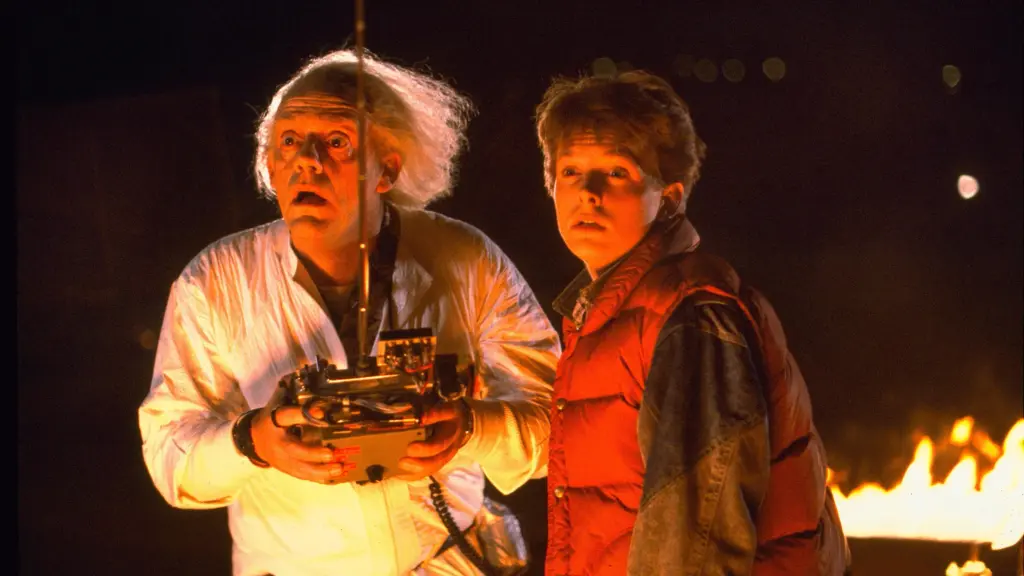 Doktor Emmett L. „Doc“ Brown (Christopher Lloyd) und Marty McFly (Michael J. Fox) schauen verdutzt. Hinter ihnen brennt Feuer und Doc Brown hat eine große Fernsteuerung in beiden Händen. | Die 5 einflussreichsten Science-Fiction-Filme aller Zeiten