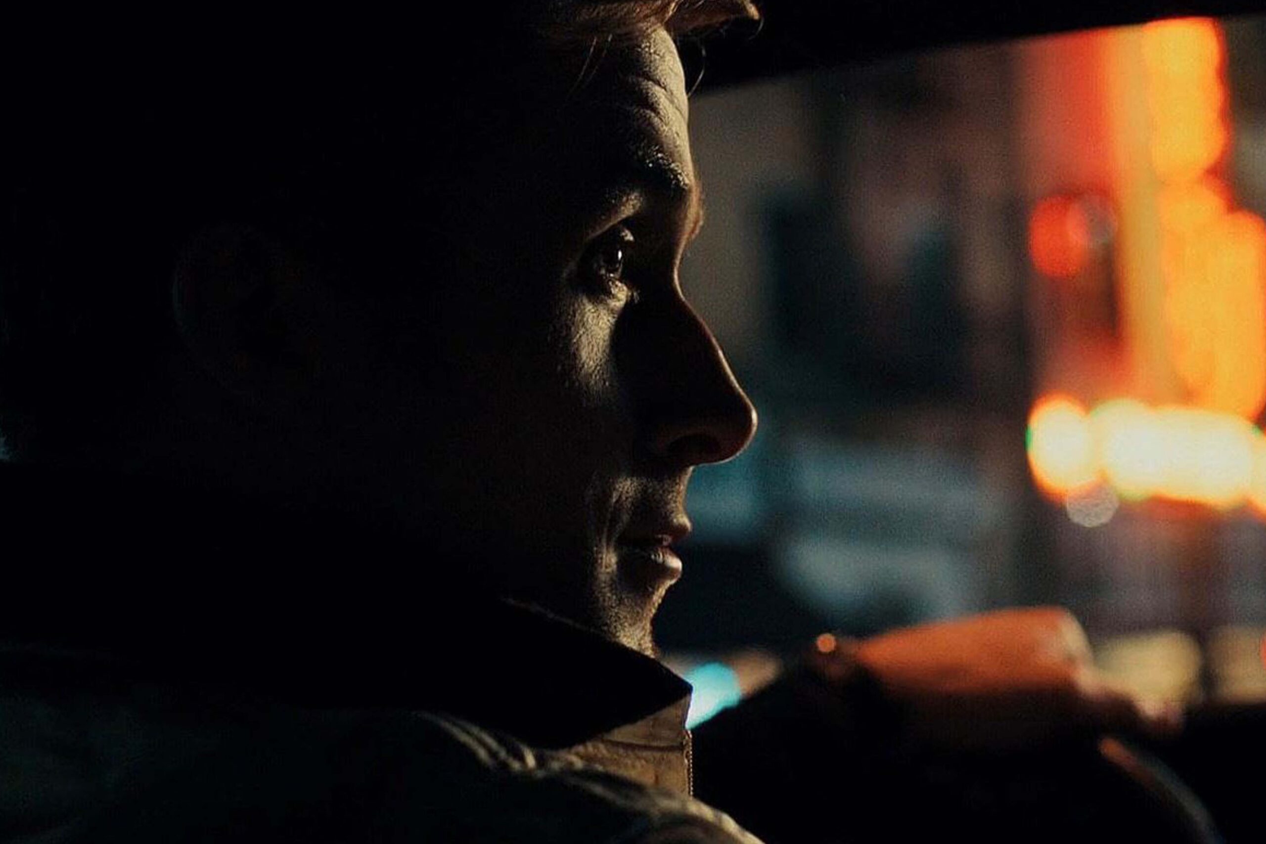 Ryan Gosling sitzt in „Drive“ seitlich im Auto, sein Gesicht von warmen, neonfarbenen Lichtern durch das Fenster beleuchtet. Er blickt konzentriert nach vorn, während unscharfe rote und orangefarbene Lichter der nächtlichen Stadt im Hintergrund vorbeiziehen. | Media Monday #775