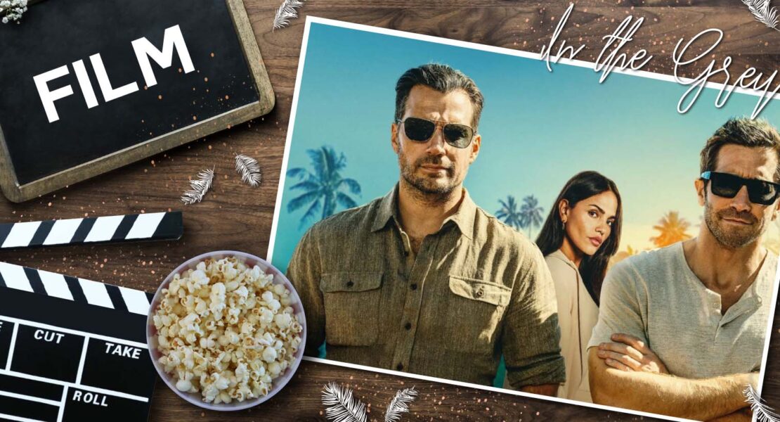Filmstill zu In the Grey: Henry Cavill, Eiza González und Jake Gyllenhaal stehen gemeinsam vor Palmen im Sonnenlicht, alle mit Sonnenbrillen, während links im Bild eine Filmklappe, Popcorn und das Wort „Film“ auf einer Tafel liegen. Die Komposition verbindet Kino‑Ästhetik mit einem Promo‑Look der drei Hauptdarsteller.