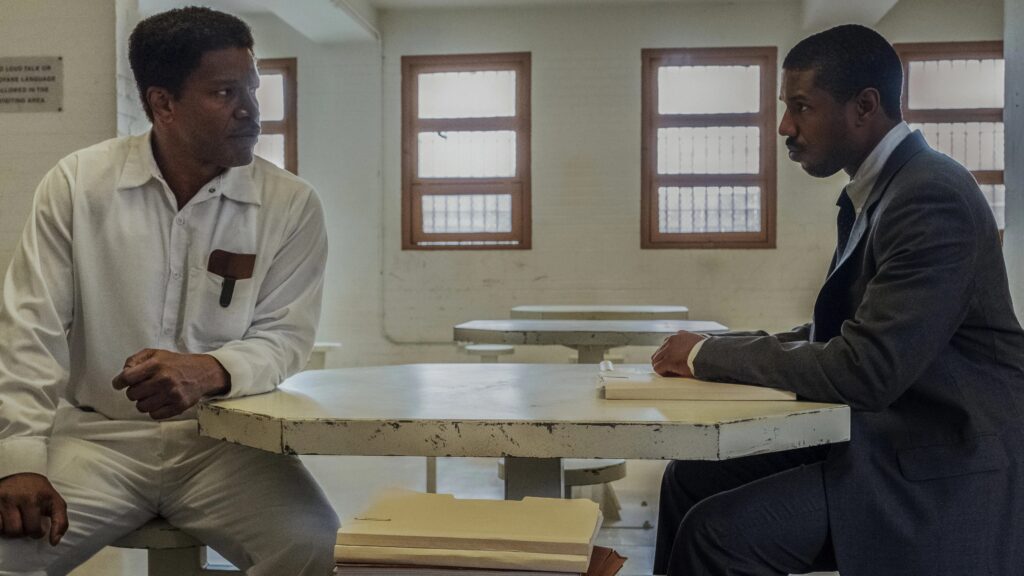 Jamie Foxx und Michael B. Jordan sitzen im Gefängnis im Besucherraum an einem Tisch - Eine Szene aus "Just Mercy" (2019) | Die 5 besten Justiz- und Gerichtsfilme