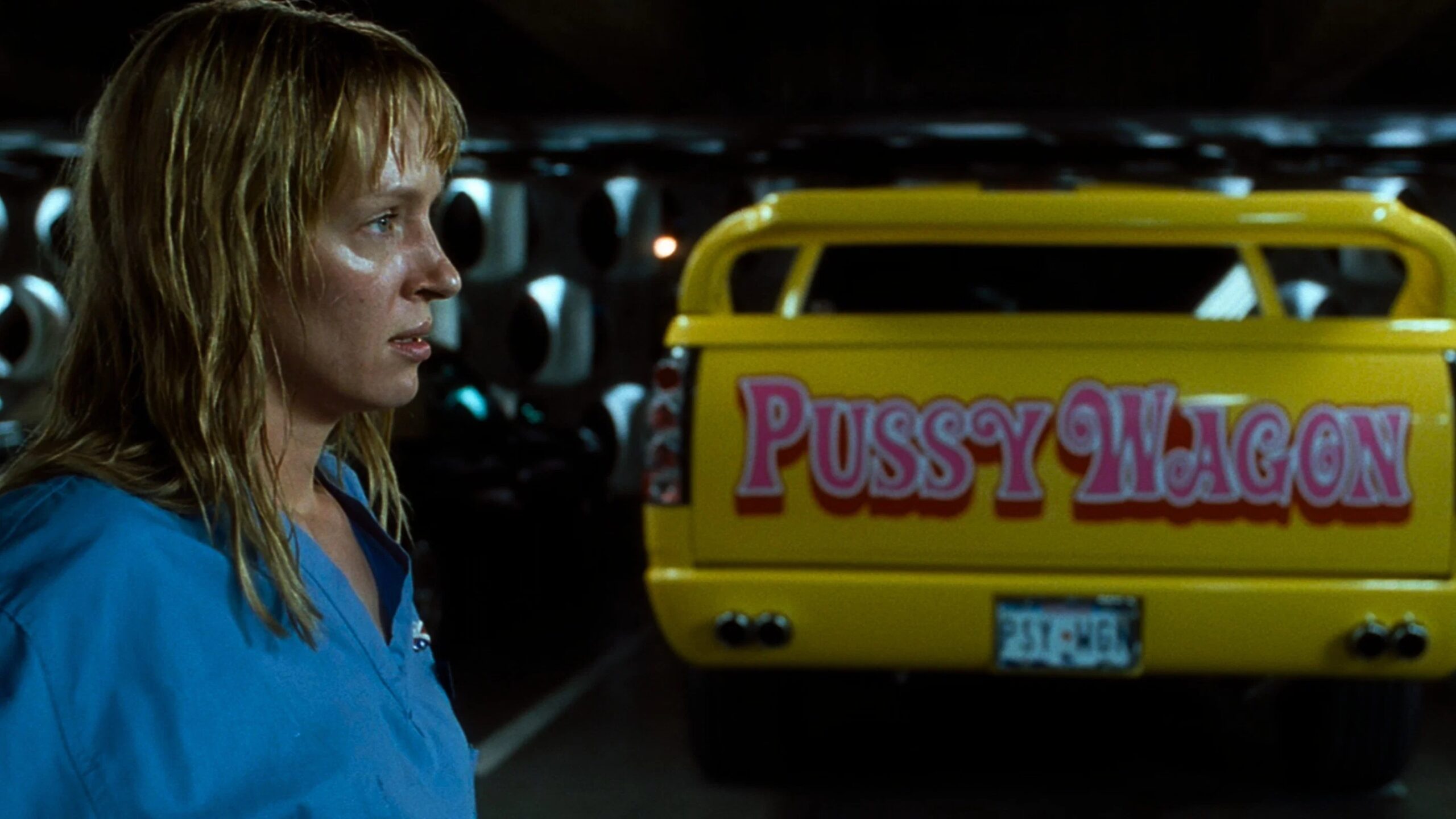 Uma Thurman ist im Profil vor einem gelben Pick-Up-Truck mit der Aufschrift Pussy Wagon zu sehen | Kill Bill: The Whole Bloody Affair