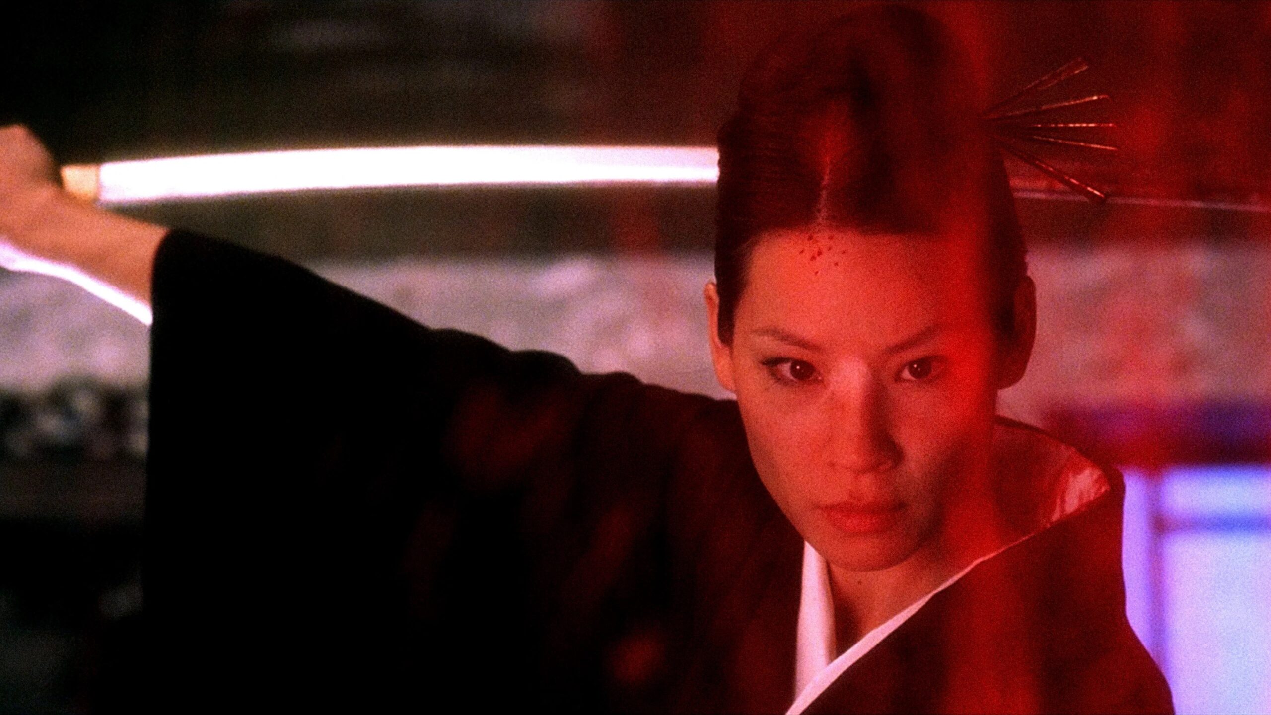 Lucy Liu als O-Ren Ishii hält ein Schwer hinter ihren Kopf, während vor ihr eine Blutfontäne hochspritzt | Kill Bill: The Whole Bloody Affair