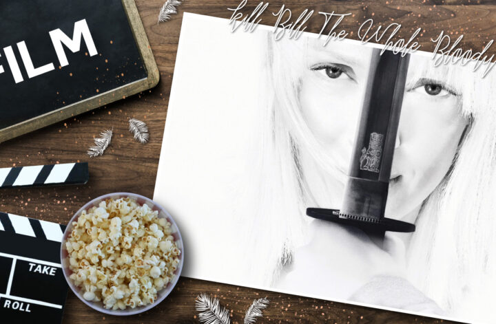 Flatlay‑Szene auf Holzuntergrund mit Filmrequisiten: links eine kleine Tafel mit dem Wort „FILM“, daneben eine schwarz‑weiße Filmklappe und eine Schale Popcorn. Rechts liegt ein schwarz‑weißes Porträt von Uma Thurman als ikonische Figur aus „Kill Bill“, die ein Katana senkrecht vor ihr Gesicht hält. Darüber steht in handschriftlicher Typografie „Kill Bill – The Whole Bloody Affair“, umgeben von dekorativen weißen Federn.