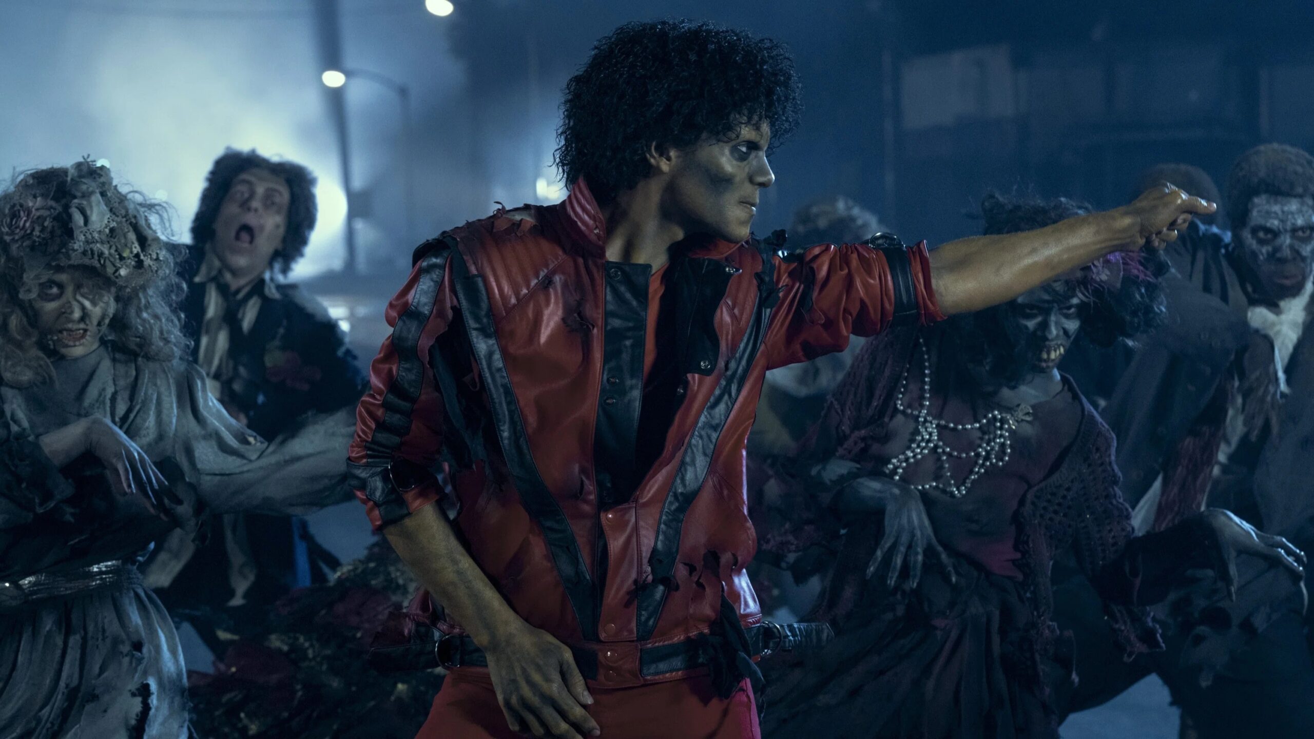 Michael (Jaafar Jackson) geschminkt als Zombie tanzt in einem roten Anzug, hinter ihm tanzen weitere als Zombie verkleidete Menschen