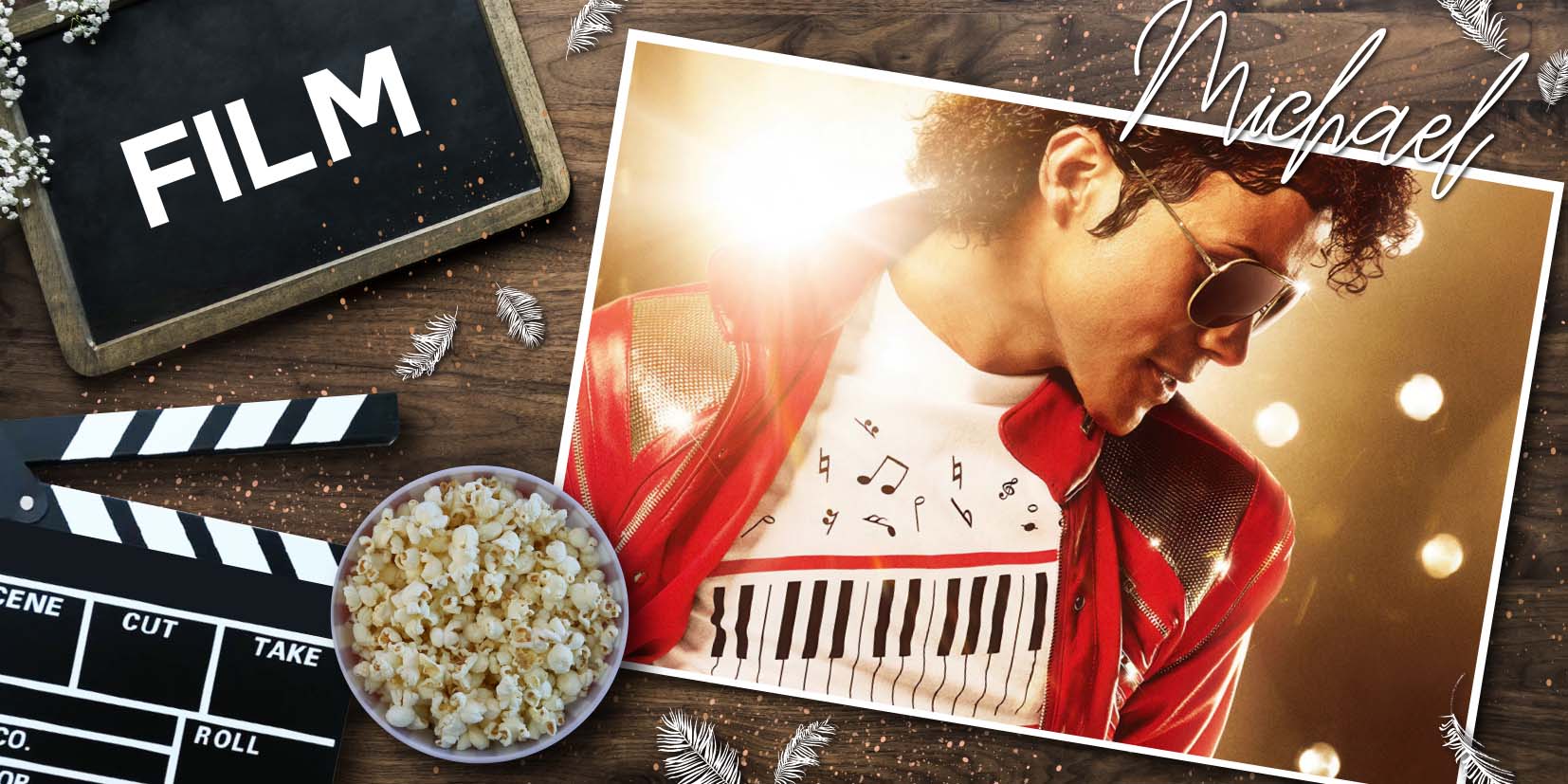 Filmklappe, Popcorn und dekorative Federn auf Holzuntergrund neben einem Porträt von Michael Jackson in roter Glitzerjacke und Musiknoten‑Shirt – stimmungsvolle Film‑ und Musik‑Collage.