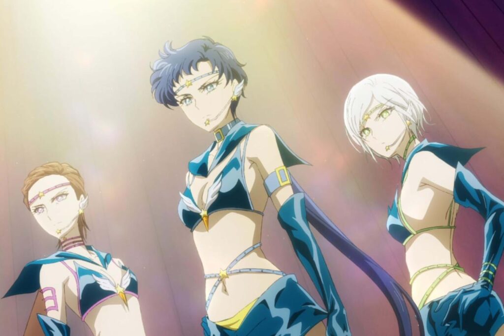 Sailor Starlights aus „Pretty Guardian Sailor Moon Cosmos“ in heroischer Pose unter warmem Spotlight; Kou Seiya, Kou Taiki und Kou Yaten als genderfluid dargestellte Sailor‑Kriegerinnen, zentrale Figuren queerer Repräsentation im Sailor‑Moon‑Universum. | Die 5 besten Queer Cinema Serien