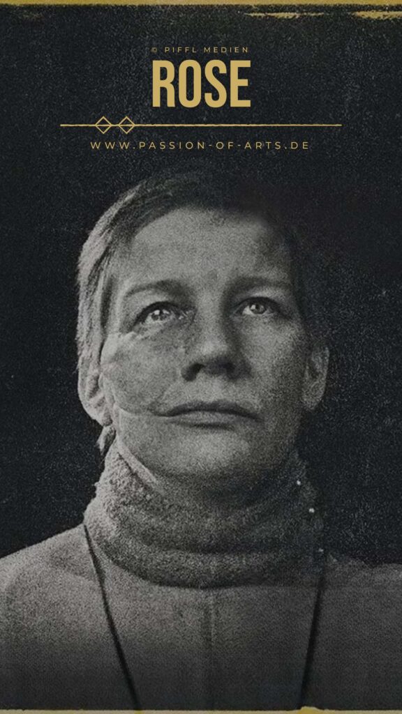 Schwarz‑weißes Porträt von Sandra Hüller, die mit ernstem, leicht nach oben gerichtetem Blick vor dunklem Hintergrund steht. Sie trägt ein hochgeschlossenes, strukturiertes Kleidungsstück, das den Hals umrahmt. Oben im Bild stehen die Worte ROSE sowie ein Copyright‑Hinweis und die Website passion‑of‑arts.de.