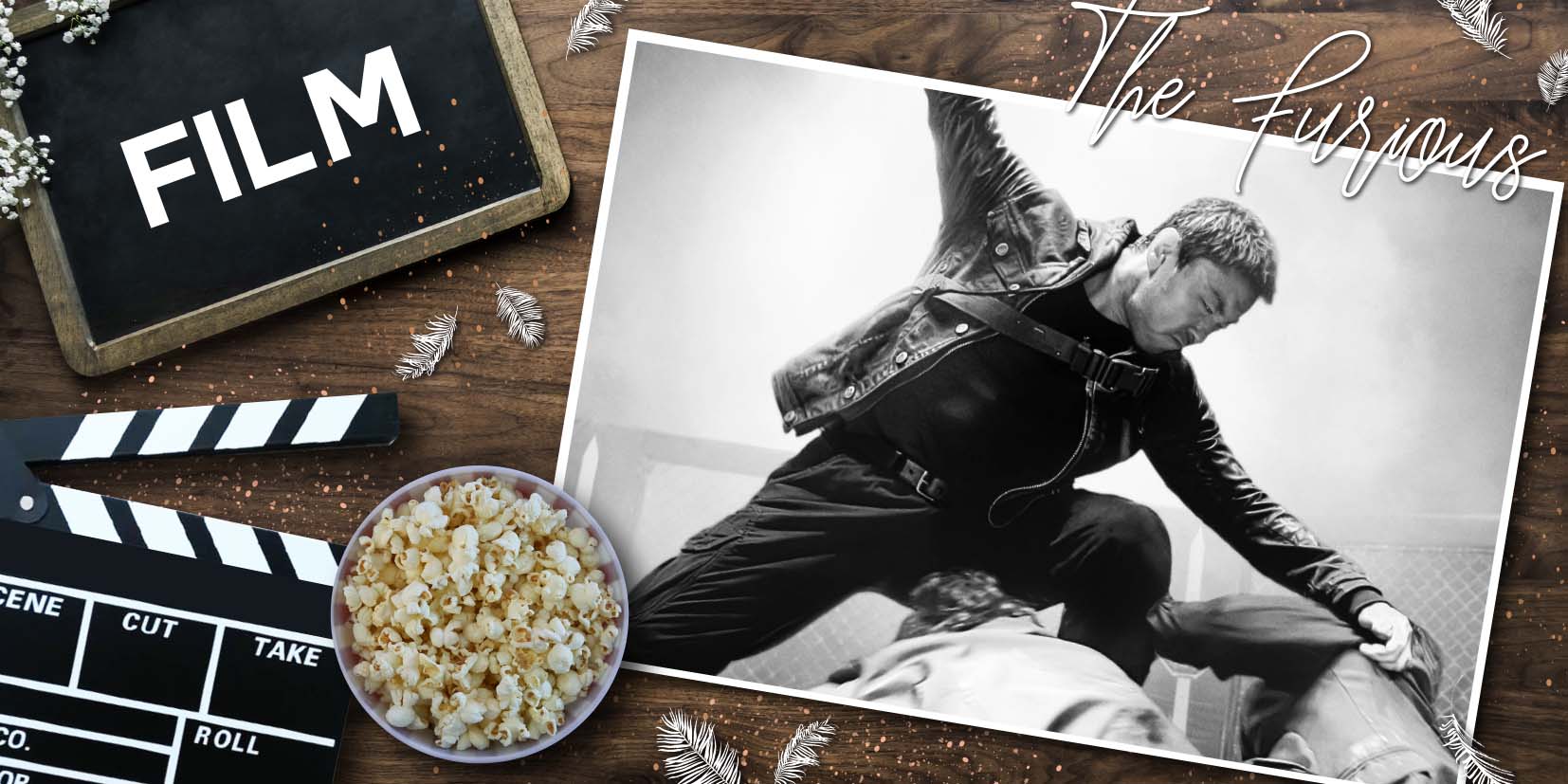 Holzuntergrund mit Filmrequisiten: Links eine Tafel mit dem Wort ‘FILM’, daneben eine Filmklappe und eine Schale Popcorn. Rechts ein Schwarz‑weiß‑Foto einer Actionkampfszene, darüber handschriftlich der Titel ‘The Furious’. Kleine Federn und Partikel liegen dekorativ verstreut.