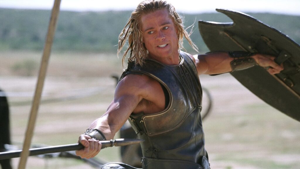 Achilles (Brad Pitt) kämpft in Rüstung, und sticht mit einer Lanze nach vorne, während er seinen Schild nach hinten streckt