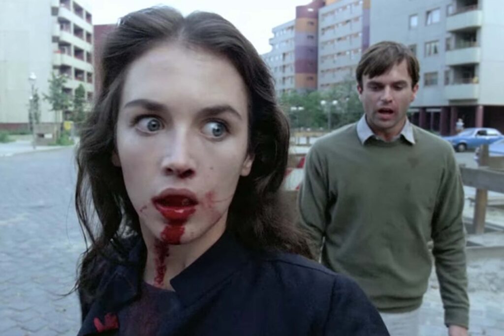 Das Bild zeigt vorne Isabelle Adjani und hinter ihr ist Sam Neill als Ehepaar Anna und Mark in Andrzej Zulawski "Possession". Ihr Mund ist blutverschmiert, er wirkt verstört und hat den Mund offen. Beide gehen durch eine HÀuserreihe von HochhÀusern. Auch ihr Blick ist wirr und wirkt verstört. | Media Monday #786