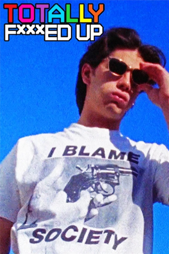 Andy (gespielt von James Duval) steht unter freiem Himmel und trägt eine Sonnenbrille sowie ein weißes T‑Shirt mit der Aufschrift „I blame society“ und einer Grafik, die eine Hand mit einem Revolver zeigt. Über ihm ist in bunten Buchstaben der Filmtitel „Totally F***ed Up“ zu sehen.