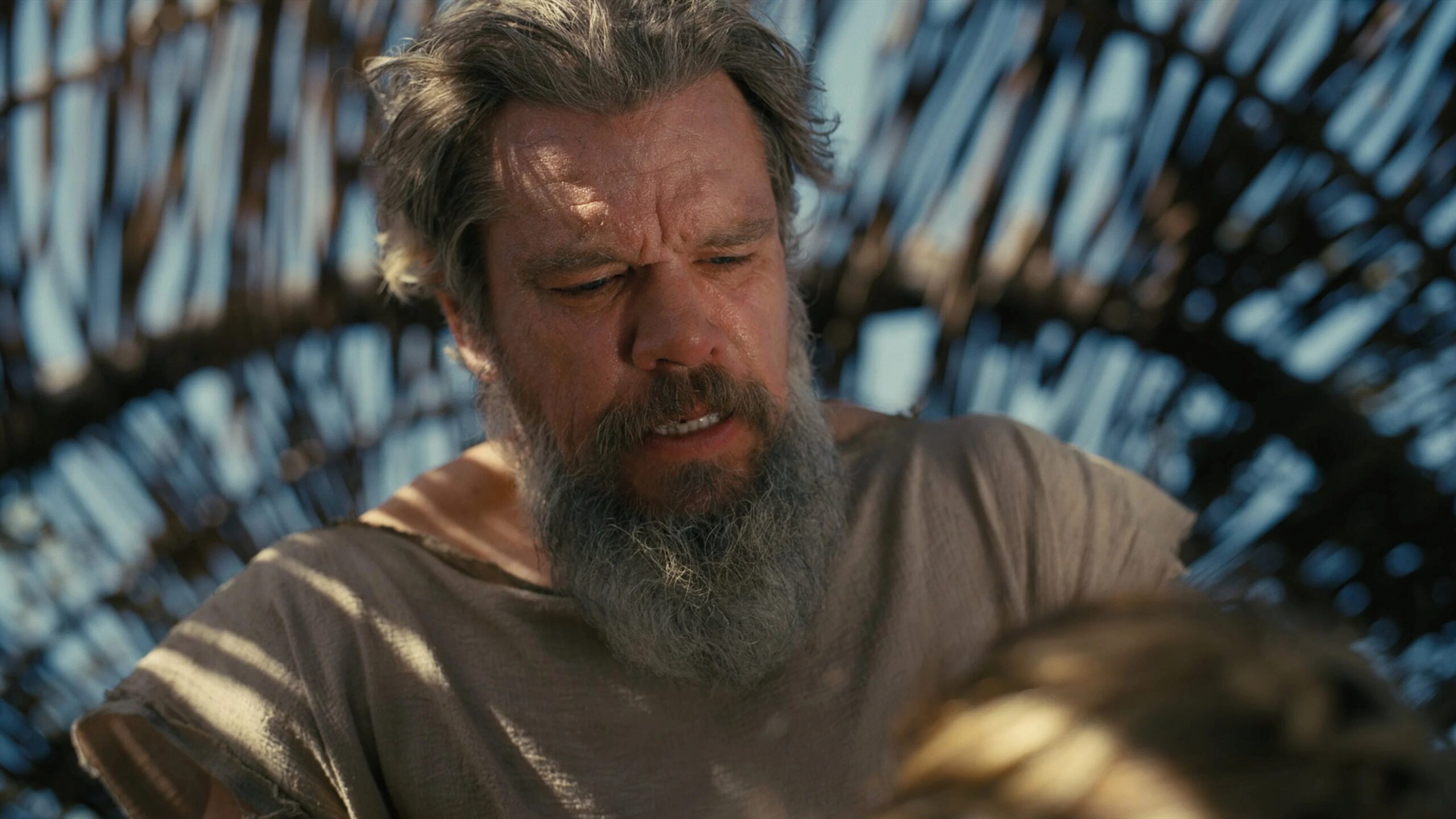 Odysseus (Matt Damon) schaut konzentriert auf eine Person vor ihm. Die Nahaufnahme zeigt den gezeichneten Helden in einem stillen Moment der Reflexion.