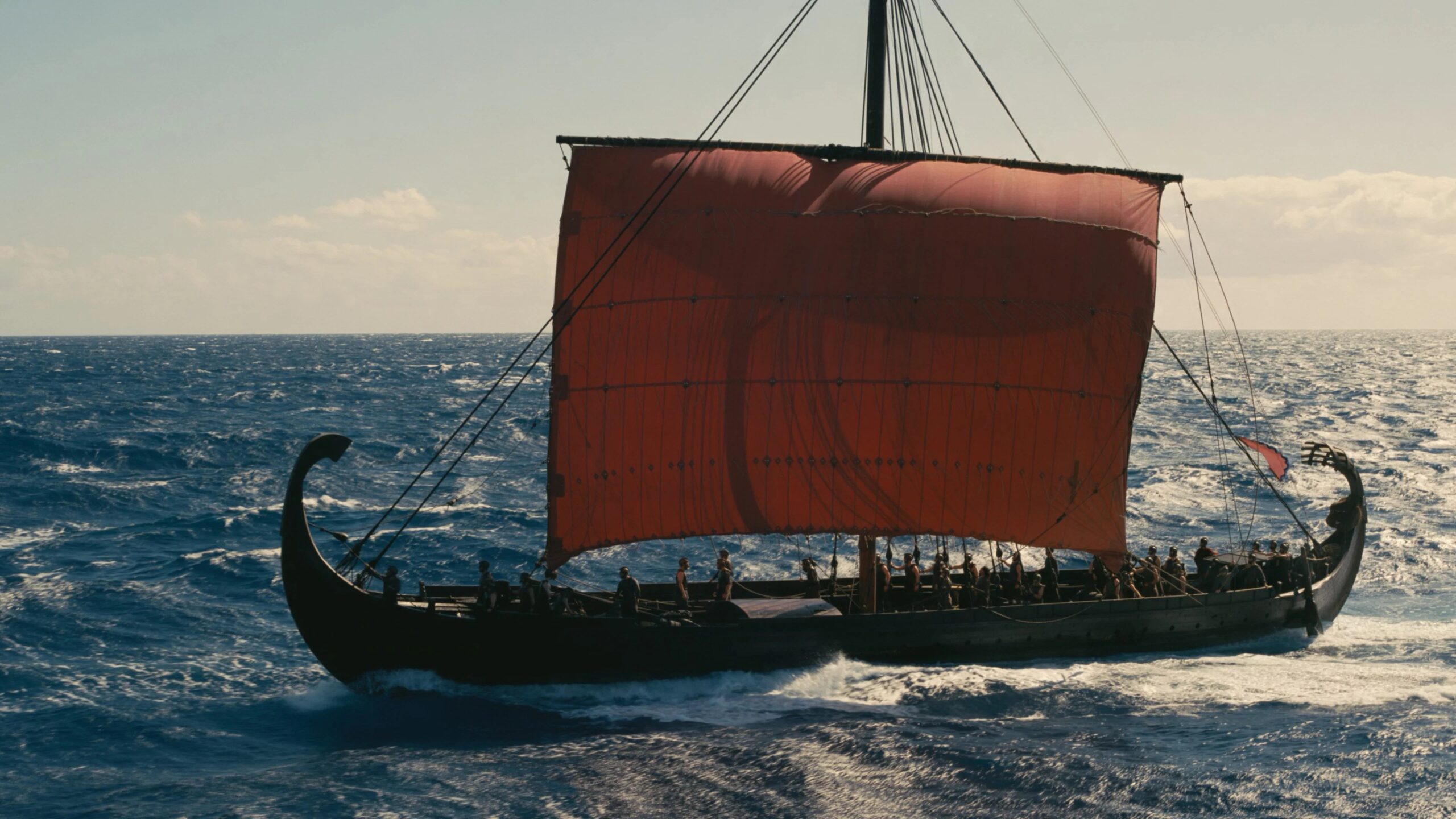 Ein griechisches Langschiff mit leuchtend rotem Segel kämpft sich über das offene Meer. Das Schiff wird zum Sinnbild für Odysseus' lange und gefahrvolle Heimreise.  | Die Odyssee