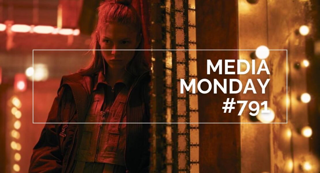 Hunter Schafer steht in einer warm ausgeleuchteten, leicht industriellen Umgebung; sie trägt eine mehrlagige Jacke und blickt seitlich in den Raum, während hinter ihr eine Reihe leuchtender Glühbirnen eine dramatische Atmosphäre erzeugt. Im Bild ist ein weißer Rahmen mit der Aufschrift „MEDIA MONDAY #791“ zu sehen; die Szene stammt aus der Serie Blade Runner 2099.