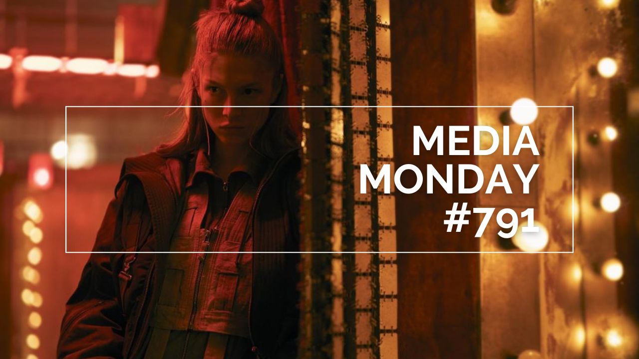 Hunter Schafer steht in einer warm ausgeleuchteten, leicht industriellen Umgebung; sie trägt eine mehrlagige Jacke und blickt seitlich in den Raum, während hinter ihr eine Reihe leuchtender Glühbirnen eine dramatische Atmosphäre erzeugt. Im Bild ist ein weißer Rahmen mit der Aufschrift „MEDIA MONDAY #791“ zu sehen; die Szene stammt aus der Serie Blade Runner 2099.
