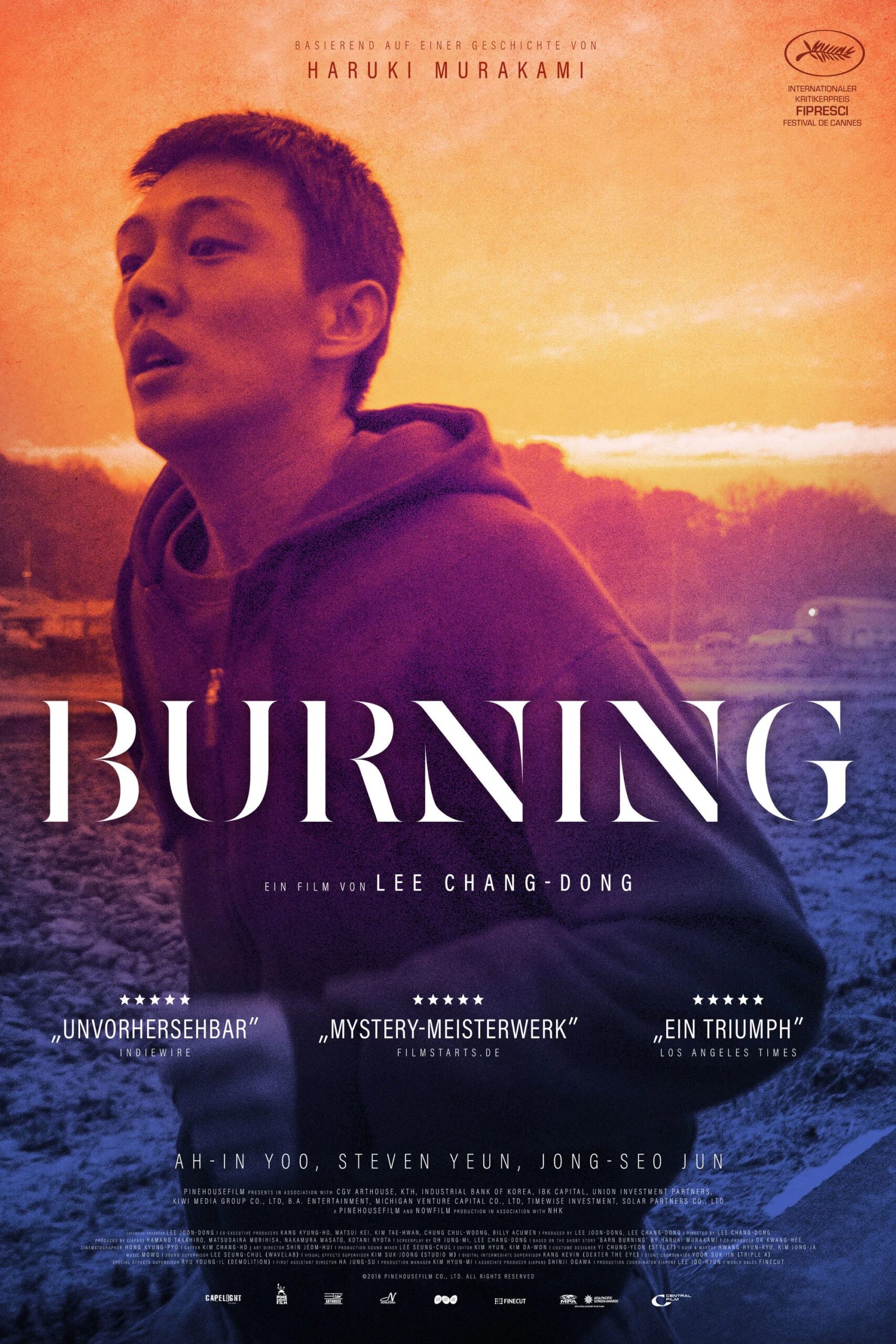 Ein Mann in Hoodie steht vor einem intensiven orange‑violetten Sonnenuntergang und blickt leicht nach oben; darüber der Filmtitel „Burning“ sowie Hinweise auf die literarische Vorlage von Haruki Murakami, den Regisseur Lee Chang‑dong und mehrere Fünf‑Sterne‑Kritiken.