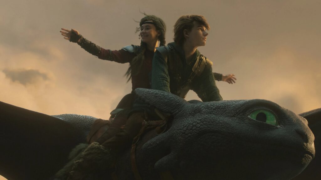 Auf dem Bild sind die beiden Hauptfiguren Hicks und Astrid zu sehen wie sie auf Hicks Drache Ohnezahn zusammen fliegen —Drachenzähmen leicht gemacht | Die 5 besten Remakes
