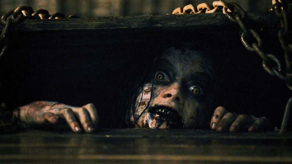 Auf dem Bild ist ein Deadite zu sehen der aus der Kellertür raus guckt — Evil Dead | 2013 © Sony Pictures Releasing | Die 5 besten Remakes