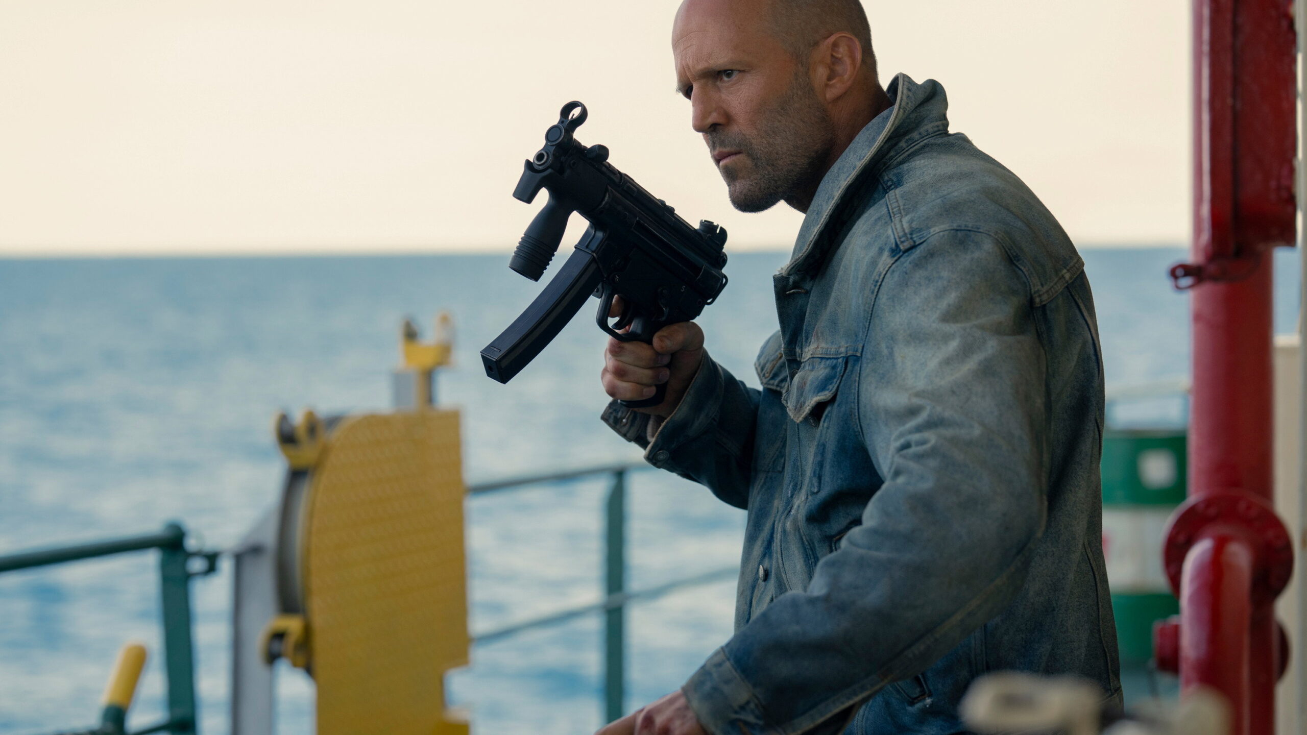 Das Bild zeigt Jason Stathman mit einem Maschinengewehr in einer Szene des Films Mutiny.