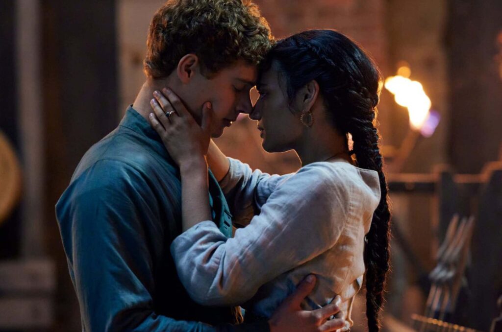 Das Bild zeigt Madeleine Madden (rechts) als Egwene Al'Vere und Josha Stradowski als Rand al'Thor aus der Serie DAS RAD DER ZEIT, die sich gegenüberstehen. Sie haben ihre Nasen und Stirne zärtlich aneinander gelegt. Sie hält sein Gesicht in ihren Händen. Das Bild zeigt die starke Zuneigung, die beide füreinander haben | Themenübersicht November 2026 – Die 5 BESTEN am DONNERSTAG