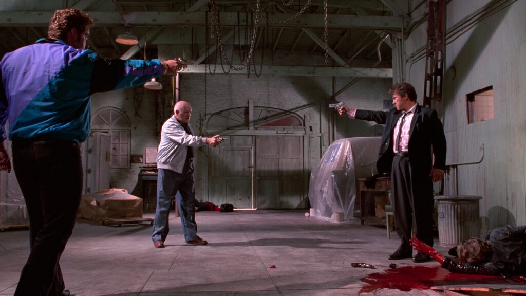 Mr. White, Joe Cabot und Nice Guy Eddie bedrohen sich gegenseitig mit Schusswaffen beim dramatischen Showdown in „Reservoir Dogs“.